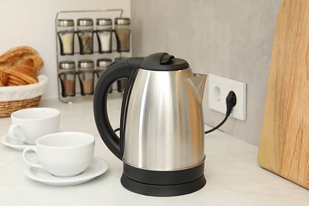 istock Electric kettle and cups on counter in kitchen 2207413929
