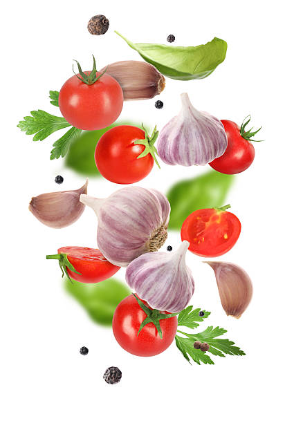 istock Fresh garlic, peppercorns, tomato and herbs falling on white background 2207413938