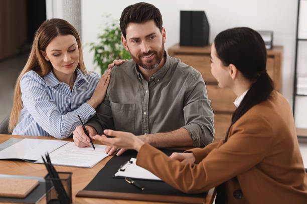 istock Couple signing document while having meeting with lawyer in office 2207415811