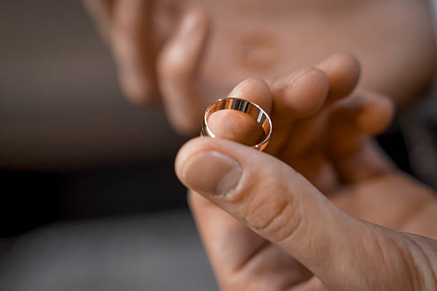 istock groom holding wedding rings close-up. 2207419251