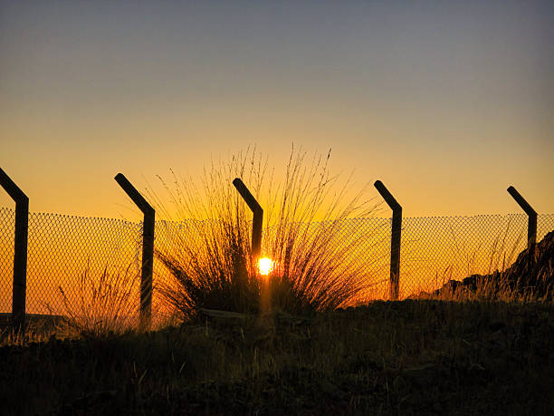 Sunset in the high Andean mountains seen from inside a mesh fence
