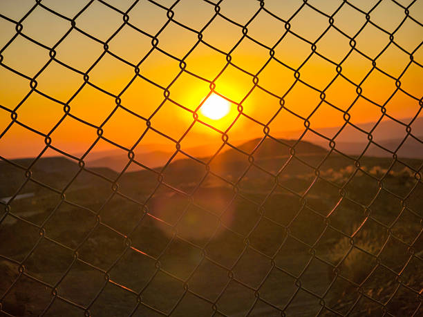 Sunset in the high Andean mountains seen from inside a mesh fence