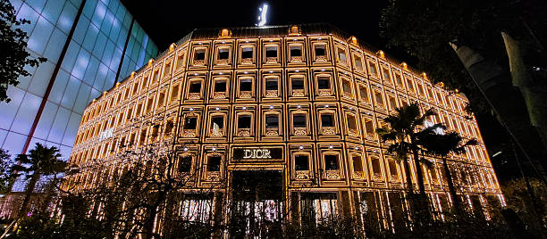 Paris, France – May 23, 2022: A vertical shot of tree with the sign of Dior shop in Paris on Champs Elysees street, France