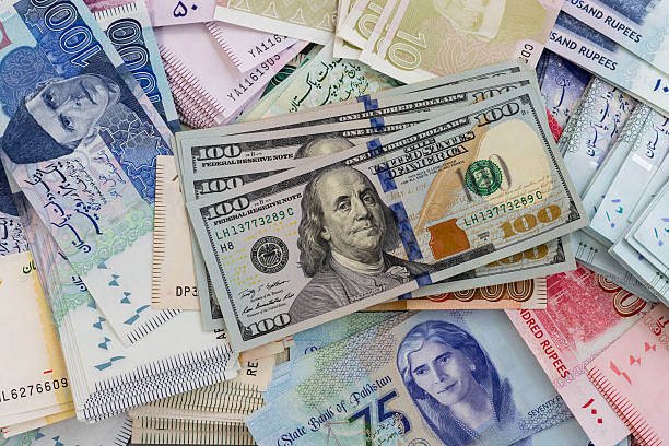 istock Pakistani Currency Mix and US 100 Dollars Banknotes. 2207436124