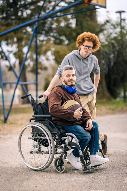 istock Active disabled man with friend playing basketball 2207437397