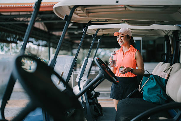 Asia Chinese female golfer drinking water getting ready in golf course weekend morning