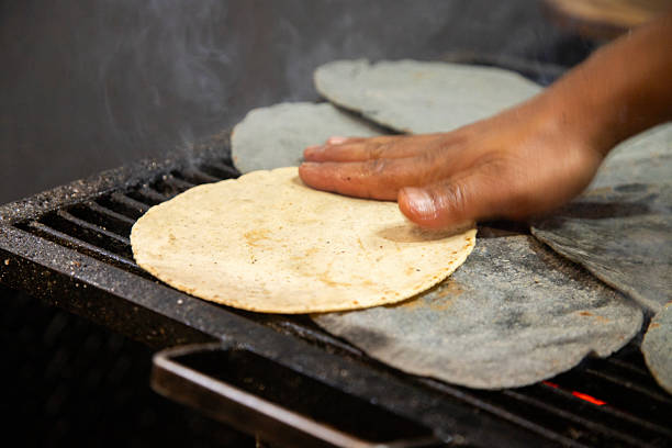 istock Squash blossom and cheese quesadilla made with purple corn on a traditional comal at the Cholula market in Puebla, Mexico. 2207442862