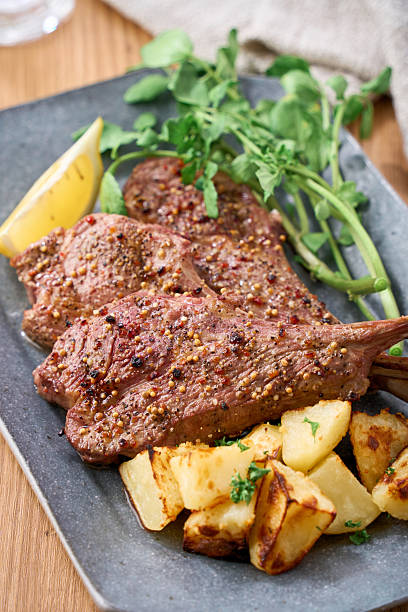 A home cooked lamb chop steak served with roast potatoes, fresh watercress and a lemon wedge. Perfect for a hearty dinner.