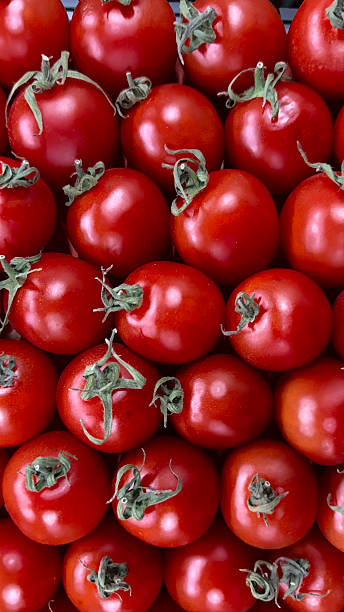 istock background of small red tomatoes with green tails 2207446195