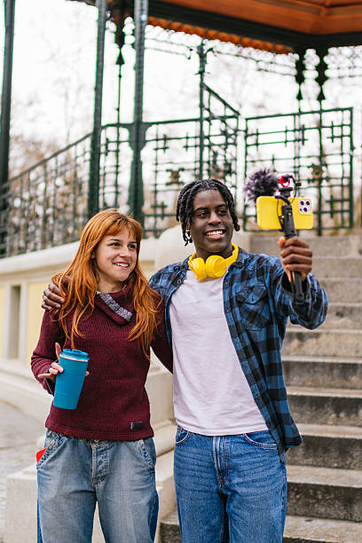 Young multiracial couple vlogging outdoors in urban park