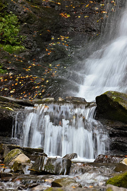 istock Stream with clear frothy water flowing among stepped rocks. 2207461611