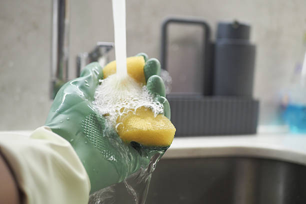istock Effectively Cleaning Dishes Using a Soft Sponge and Warm Water Today 2207463382