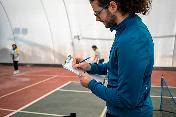 istock male referee is writing points on foreground focus on foreground female pickleball players are background horizontal pickleball still 2207464523