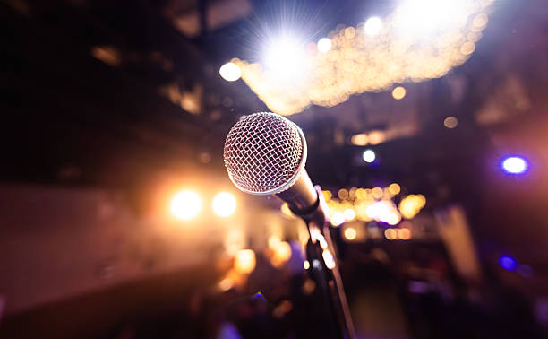 istock Microphone on stage against a background of auditorium. 2207465263