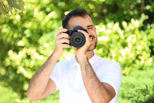 istock Young photographer with camera in the park 2207467444