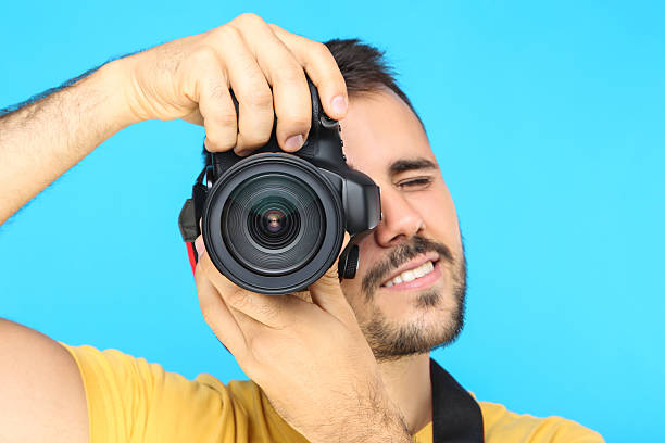 istock Young photographer with camera on blue background 2207467862