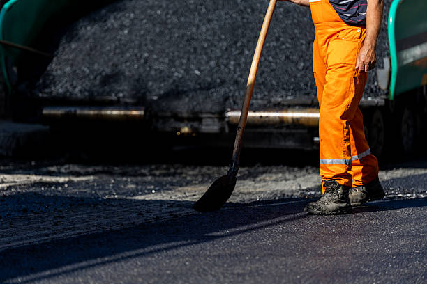 istock Road construction worker shoveling asphalt at a street project site during the day 2207468535