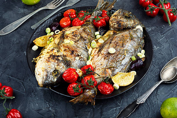 istock Grilled dorado fish with lemon, rosemary and vegetables. 2207471066