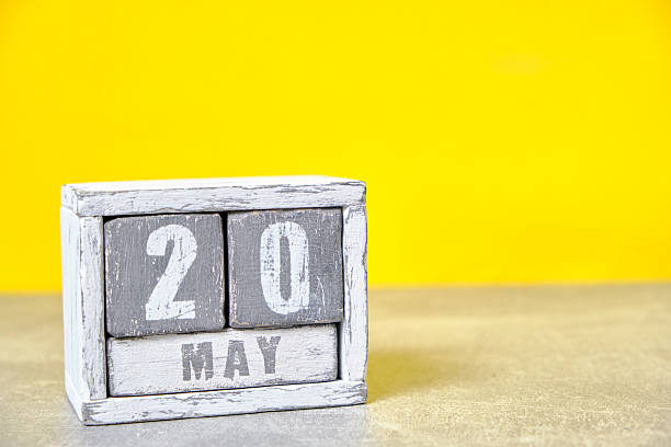 istock May 20 calendar made wooden cubes yellow background.With an empty space for your text. 2207472450