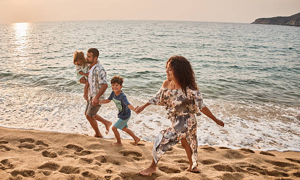 istock A family run down a tropical paradise beach during sunset 2207473092