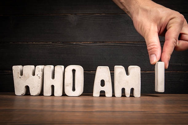 istock Hand Placing WHO AM I Text on Wooden Desk 2207479111