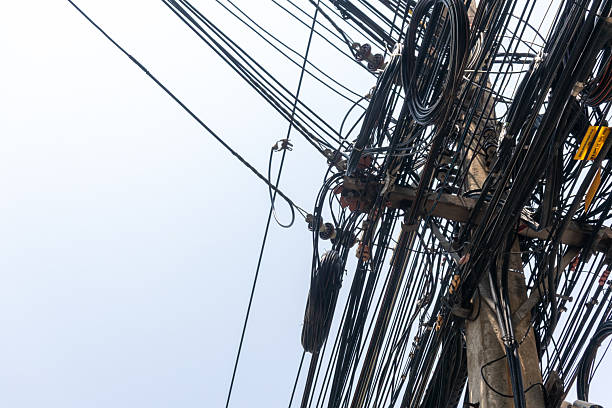istock Dense Network of Power Lines and Cables Against a Gray Sky 2207479172