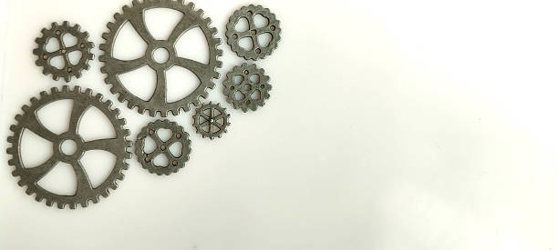 Mechanical gears and cogs arrangement industrial workshop close-up image neutral background creative engineering concept