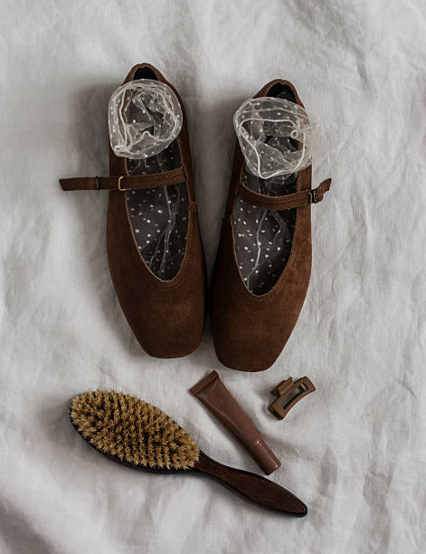 Brown suede women's shoes, socks, comb, cosmetics on a light background, top view