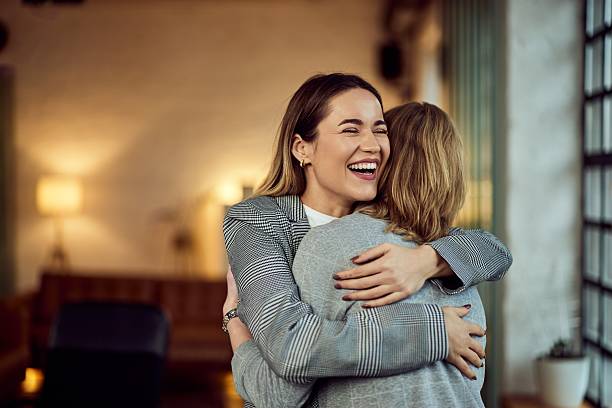 istock Two Women Hugging and Smiling in a Cozy Indoor Setting 2207486150