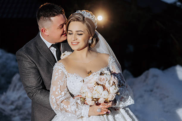 istock A bride and groom are hugging and the bride is holding a bouquet 2207488208