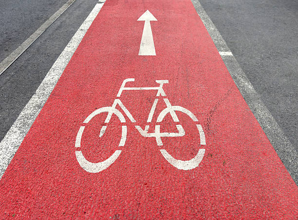 istock Bike lane with bicycle symbol on red pathway and white arrow indicating direction 2207489410
