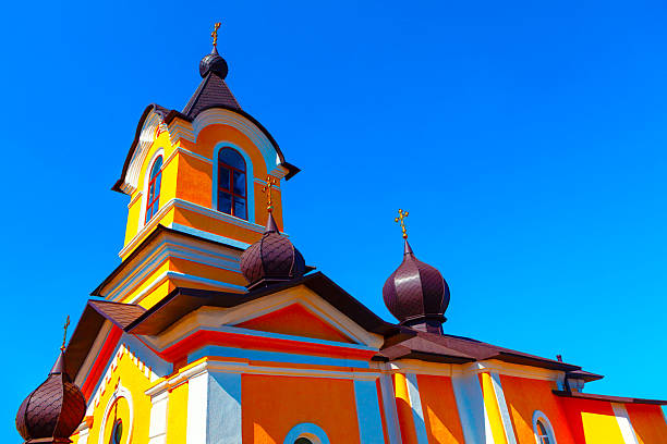 Tipova Church from Moldova. Vibrant orange and yellow church architecture against a clear blue sky