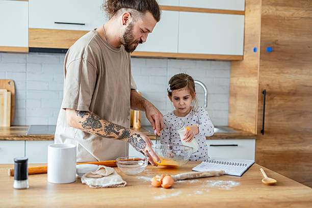 istock Daughter helping her father in kitchen 2207490957