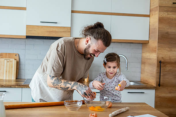 istock Daughter helping her father in kitchen 2207490970