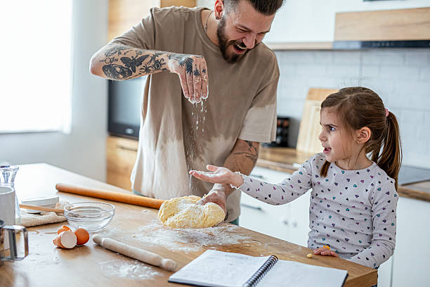 istock Father teaching his daughter how to bake cookies 2207491138