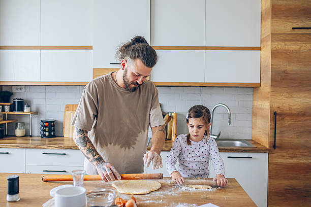 istock Father teaching his daughter how to bake cookies 2207491149