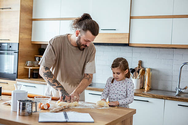 istock Father teaching his daughter how to bake cookies 2207491159