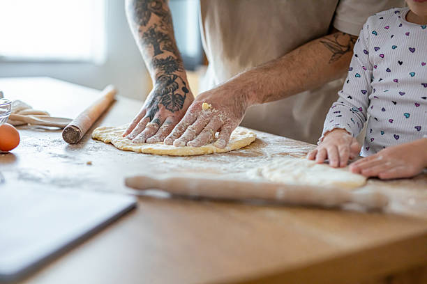 istock Father teaching his daughter how to bake cookies 2207491191