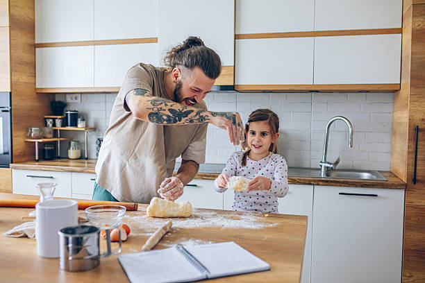 istock Father teaching his daughter how to bake cookies 2207491246