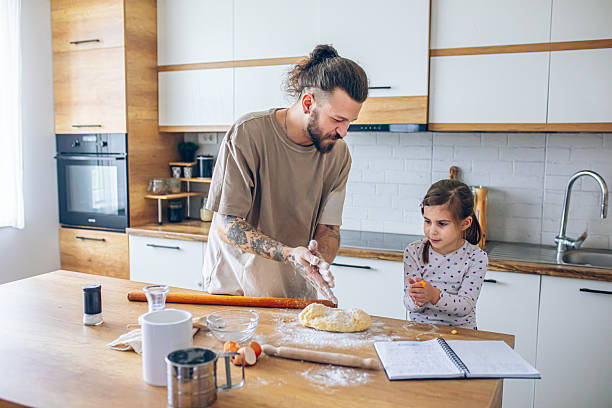 istock Father teaching his daughter how to bake cookies 2207491313