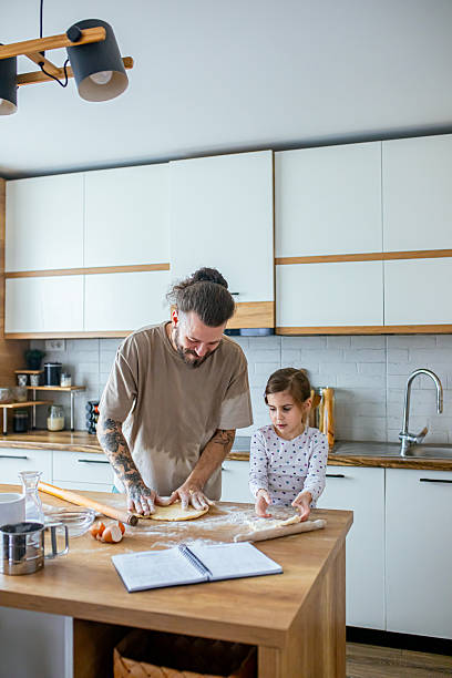 istock Father teaching his daughter how to bake cookies 2207491391