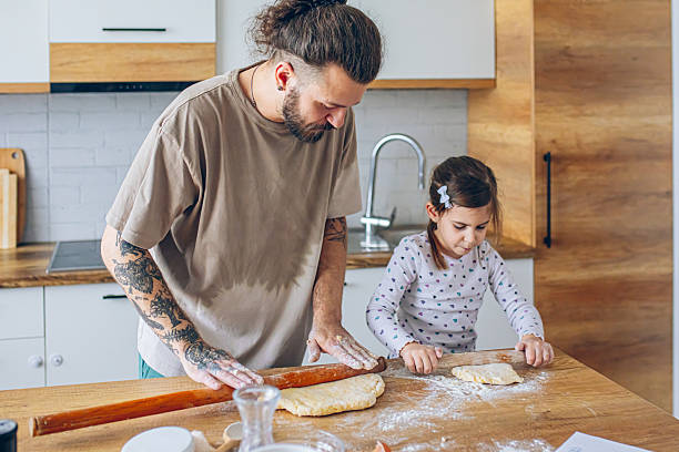 istock Father teaching his daughter how to bake cookies 2207491487