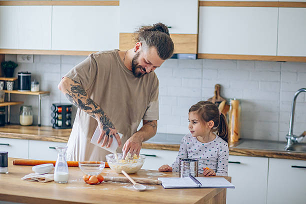 istock Father teaching his daughter how to bake cookies 2207491520