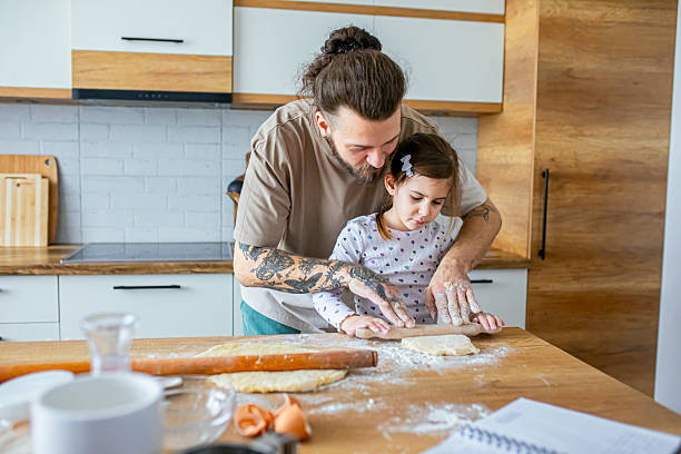 istock Father teaching his daughter how to bake cookies 2207491542