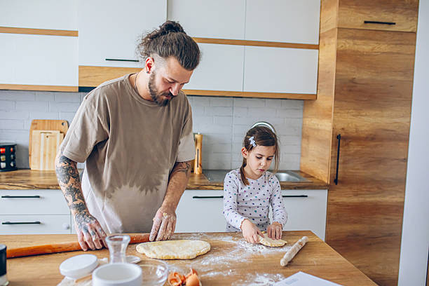 istock Father teaching his daughter how to bake cookies 2207491725