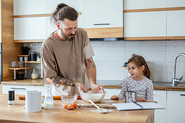 istock Father teaching his daughter how to bake cookies 2207491741