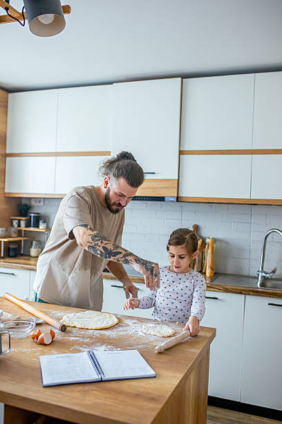 Happy father and daughter having fun while cooking pastry