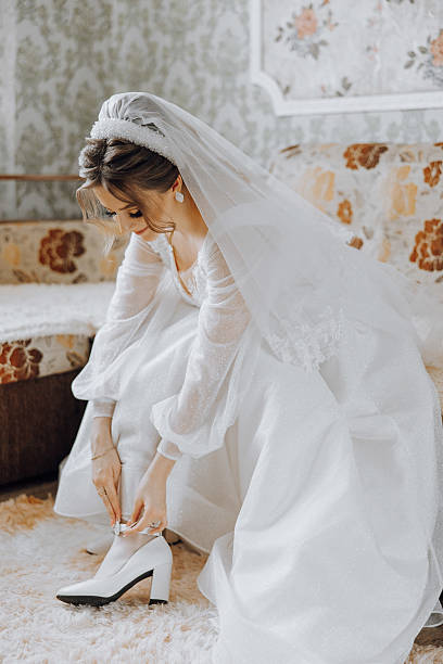 istock A bride is getting ready for her wedding and is putting on her wedding shoes 2207492454