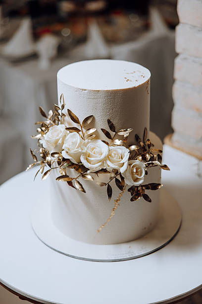 istock A white cake with gold leaves and white roses on top 2207492525