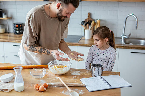 istock Happy father and daughter having fun while cooking pastry 2207492543